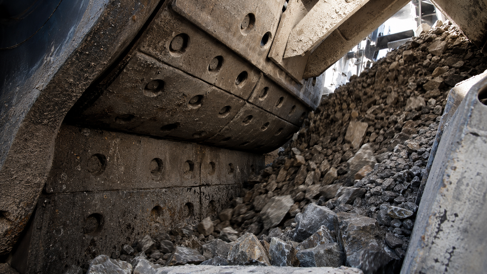 Abrasion resistant castings lining industrial crushing equipment as rocks and aggregate move through the heavy-duty processing system.